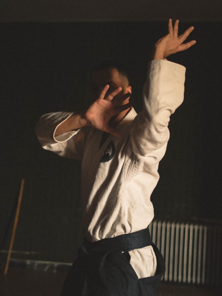 A man standing in a room holding his arms up in the air